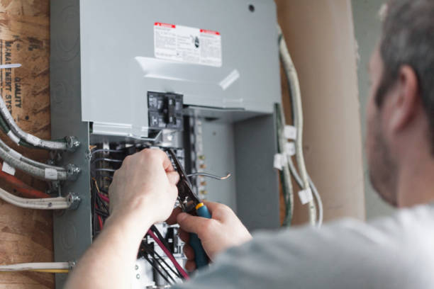 Technician testing breakers inside an electrical control panel