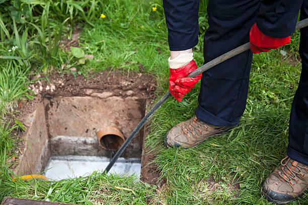 Technician working at a bathroom basin to clear a blocked drain