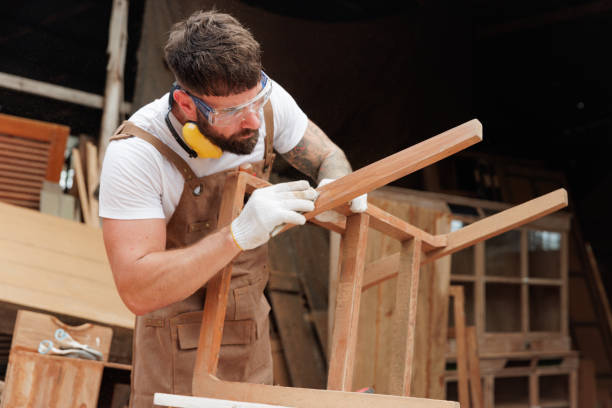 Craftsman sanding and restoring a wooden chair frame