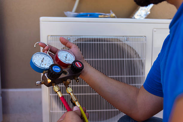 Technician testing AC components with tools during a performance check