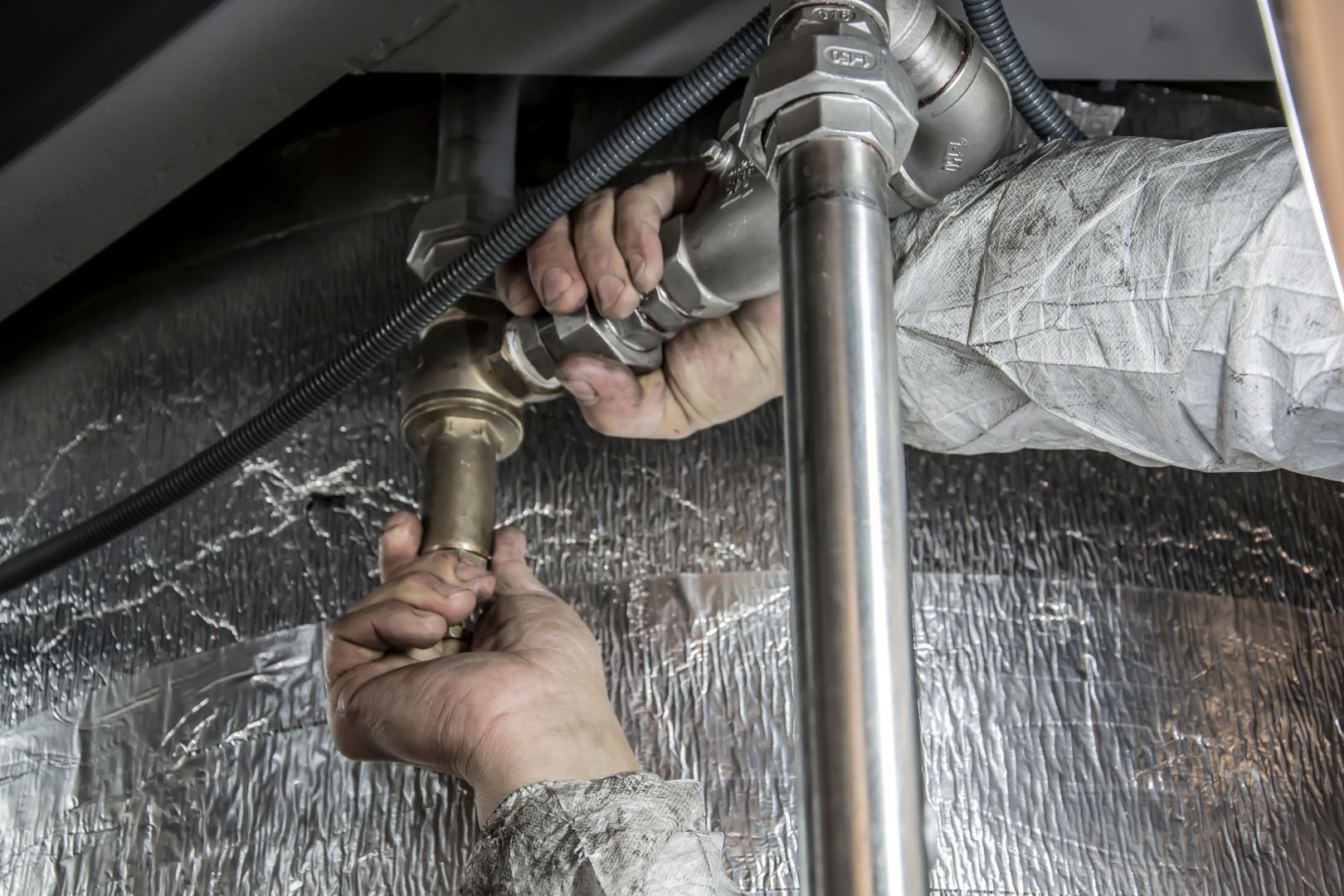 Plumber fitting steel water pipes with a wrench